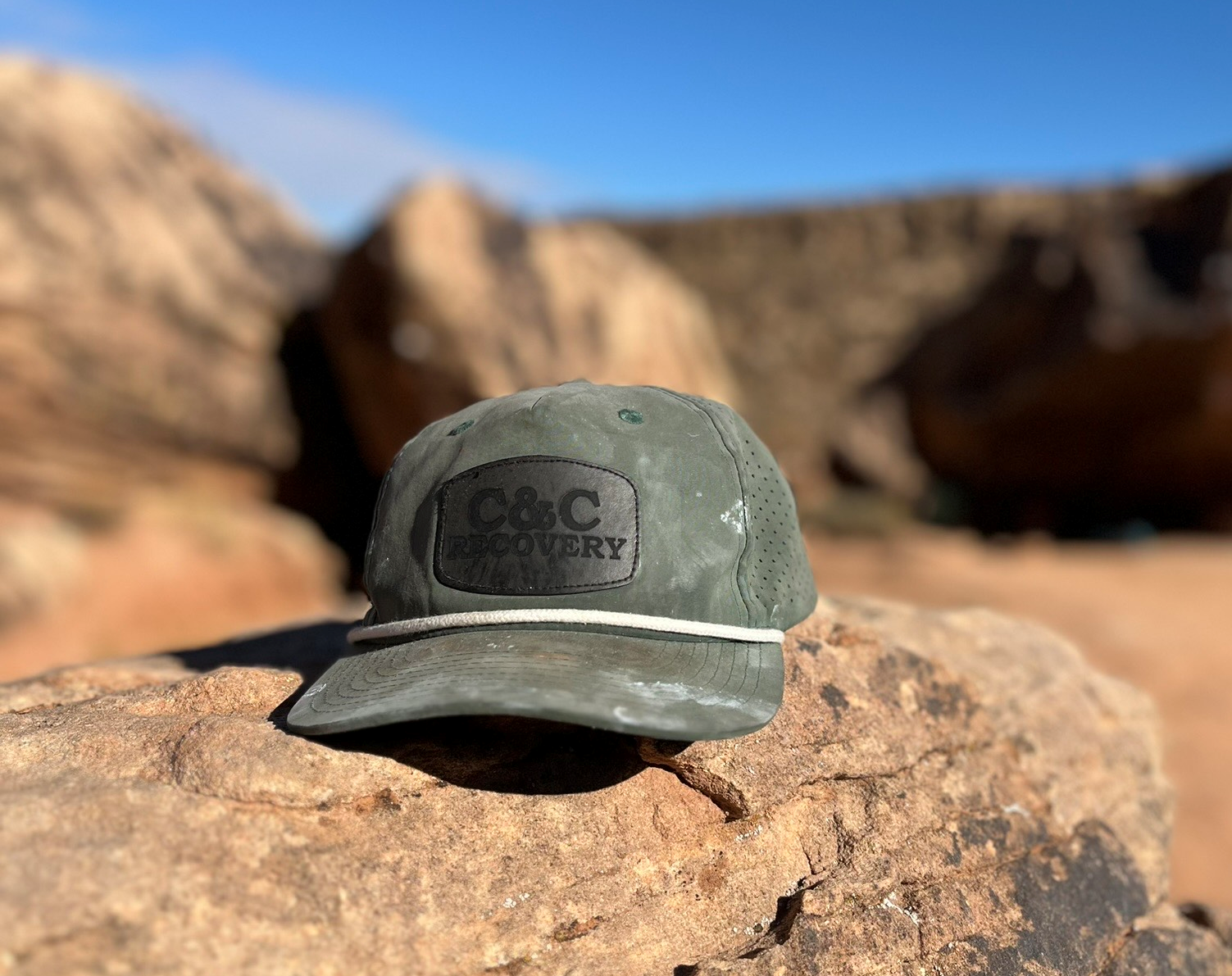 C&C Recovery field cap resting on red sandstone